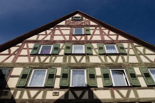 Half-timbered house with green and red bar and blue sky