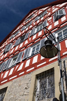 Half-timbered house with red half-timbering in portrait format