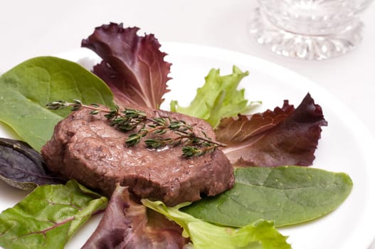 Beef tenderloin with thyme on lettuce
