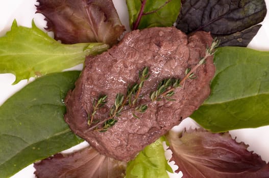 Roasted beef fillet with thyme on lettuce