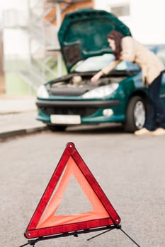 Woman talking on the phone car breakdown hood checking trouble
