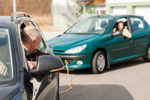 Man helping woman by pulling her car problem breakdown cable