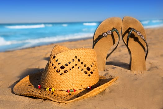 golden sand beach with summer hat and sandals as summer vacation symbol