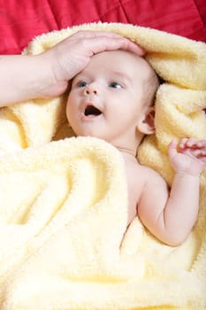 Newborn - close-up focus baby boy with yelow blanket and mother hand caressing