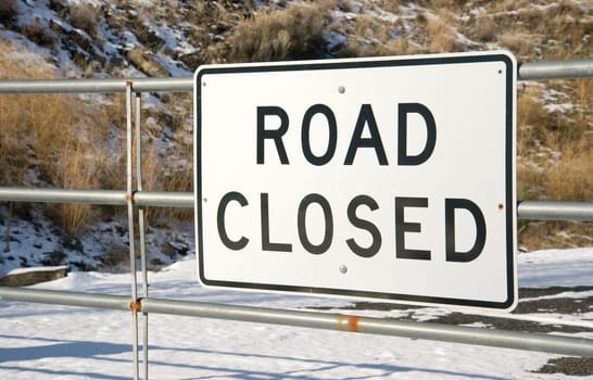 A gate with a sign that says "road closed"" found in the dead of winter"