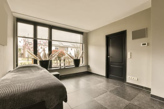 a hotel room with a bed and two large windows looking out onto the street in the photo is taken from inside