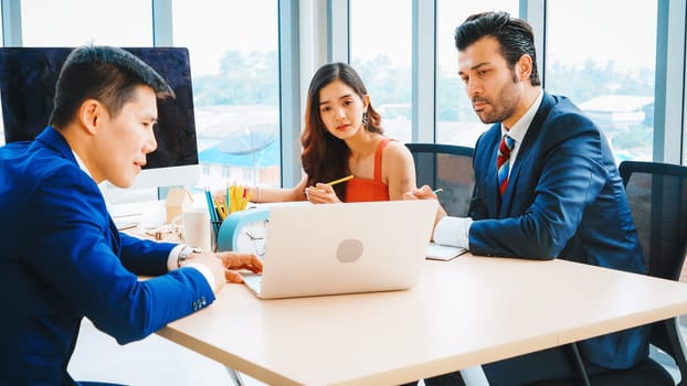 Smart businessman and businesswoman talking discussion in group meeting at office table in a modern office interior. Business collaboration strategic planning and brainstorming of coworkers. Jivy
