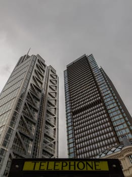 London, UK - Oct 23, 2023 - Looking Up of Public telephone sign in front of skyscraper. View of Liverpool street modern office buildings which major London financial district main, London shining buildings, Architectural exterior view, Space for text, Selective focus.