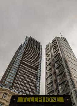 London, UK - Oct 23, 2023 - Looking Up of Public telephone sign in front of skyscraper. View of Liverpool street modern office buildings which major London financial district main, London shining buildings, Architectural exterior view, Space for text, Selective focus.