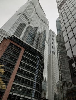 London, UK - Oct 23, 2023 - Looking up to highrise office build containing architecture modern design. View of the skyscraper from below, its ultra modern contemporary buildings with unique architecture, Space for text, Selective focus.