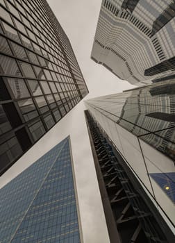 London, UK - Oct 23, 2023 - Looking up to highrise office build containing architecture modern design. View of the skyscraper from below, its ultra modern contemporary buildings with unique architecture, Space for text, Selective focus.