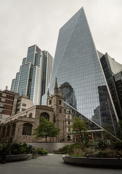 London, UK - Oct 23, 2023 - St Andrew Undershaft Church in front of modern skyscraper buildings background. Architectural view of old and new buildings in contrasting classical and modern designs, Space for text, Selective focus.