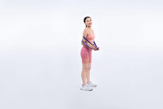 Vigorous energetic woman in sportswear portrait stretching resistance sport band. Young athletic asian woman strength and endurance training session workout routine concept on isolated background.