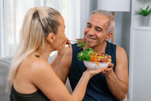 Healthy senior couple in sportswear with a bowl of fruit and vegetable. Healthy cuisine nutrition and vegan lifestyle for fitness body physique concept. Clout
