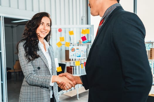 Business people handshake in corporate office showing professional agreement on a financial deal contract. Jivy