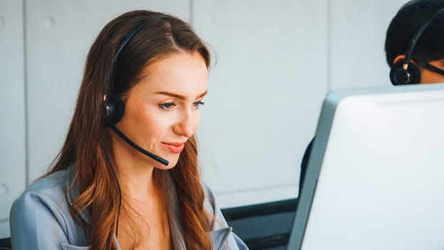 Business people wearing headset working in office to support remote customer or colleague. Call center, telemarketing, customer support agent provide service on telephone video conference call. Jivy