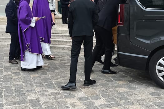 Funeral service loading the coffin into the hearse