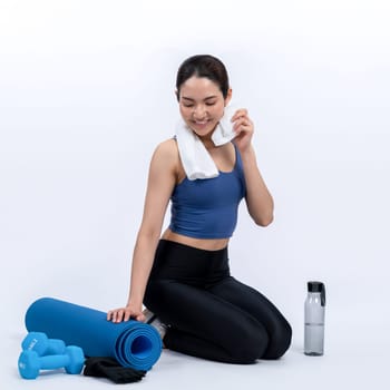 Athletic and sporty asian woman resting after intensive cardio workout training. Healthy exercising and fit body care lifestyle pursuit in studio shot isolated background. Vigorous