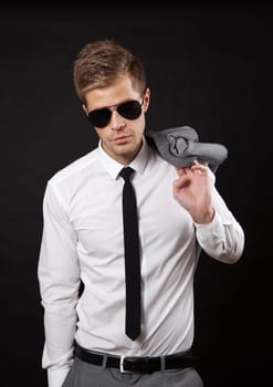 Portrait of a confident businessman wearing sunglasses on dark background