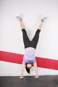 Brunette handstand woman isolated on gym