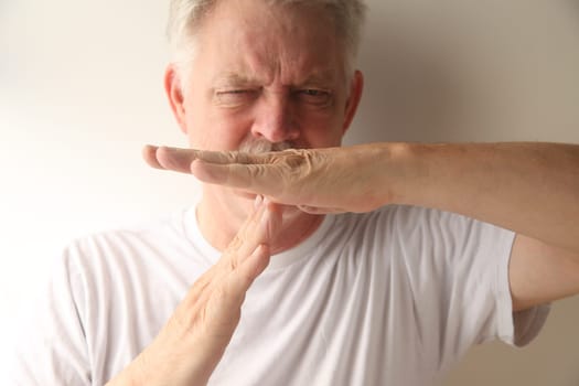 an older man gives the timeout gesture
