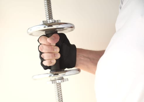 plump man holds a weight in his gloved hand