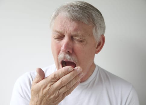senior man getting ready to yawn or sneeze