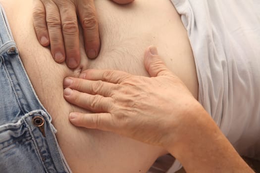 a reclining man indicates where he is hurting