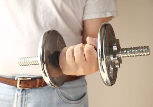 a man holds a heavy weight in his hand