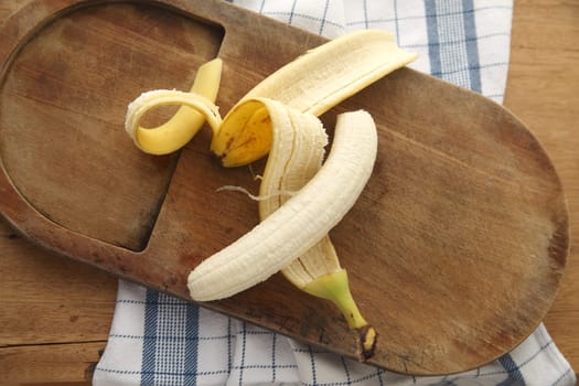peeled banana on cutting board