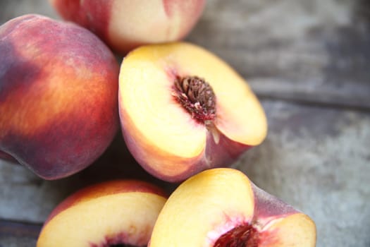 fresh peaches, some cut, on an old wood background