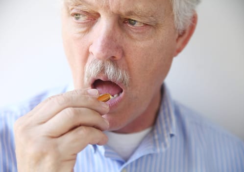 man taking fish oil pill