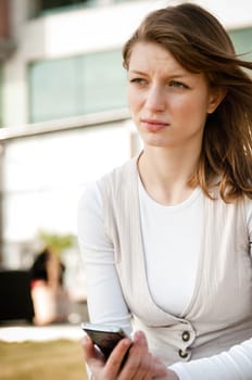 Unhappy woman with mobile phone after reeceiving bad message