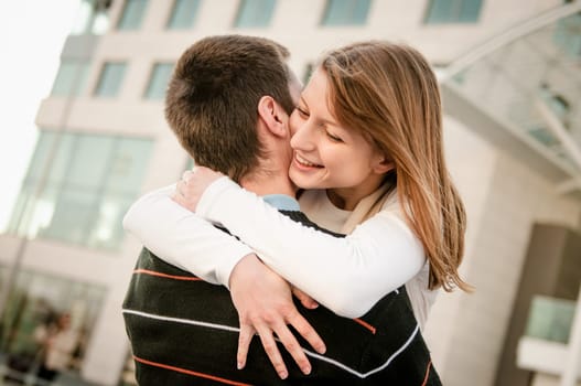 Young happy smiling couple in embracement - outdoor on street