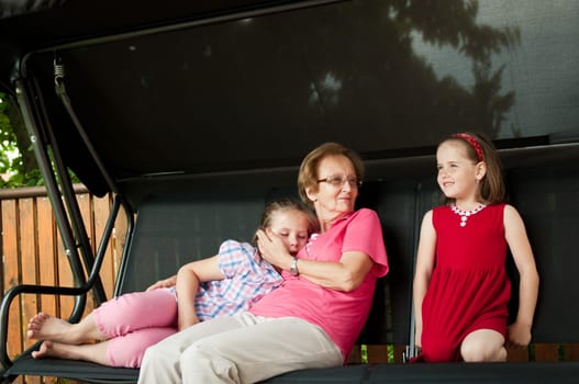 Grandmother with her crandchildren, one is sleeping another with happy expression