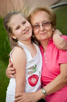 Outdoors portrait of grandmother with grandchild - real candid expression