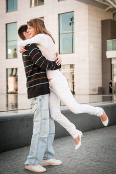 Happy couple - young man welcomes her girlfriend on street - full lenght composition