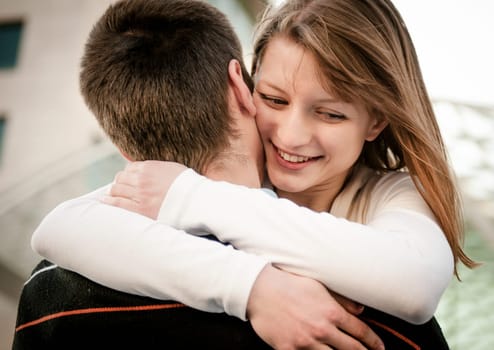 Young happy smiling couple in embracement - outdoor on street