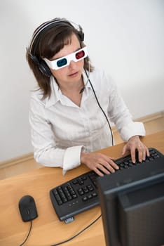 Business person (young woman with 3d glasses) works at table with computer