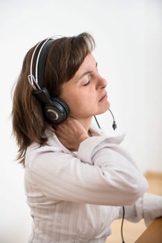 Young business woman with neck pain working at computer