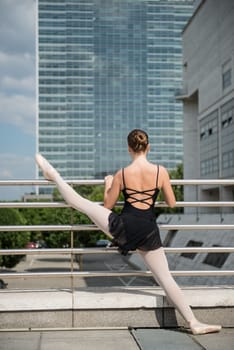 Ballet dancer (ballerina) dancing on street with business buildings in background