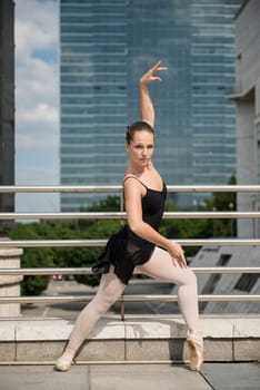 Ballet dancer (ballerina) dancing on street with business buildings in background