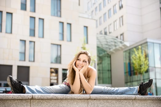 Outdoor portrait of young flexible smiling woman - urban surrounding