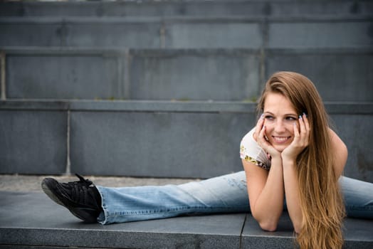 Outdoor portrait of young flexible smiling woman - river in background