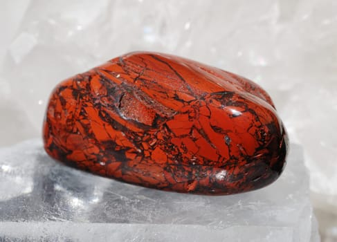 Red jasper gem energized on druze of quartz crystals. This gem is used as a jewel stone and also in alternative medicine and esoterics (red jasper connected with base chakra).
