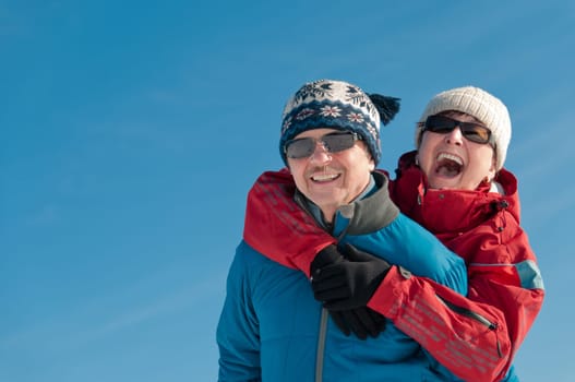 Active senior couple - smiling mature man and woman outdoor in winter
