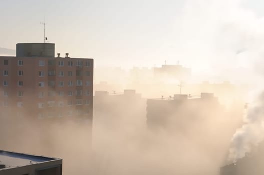Residential area in fog and smog with chimney in background