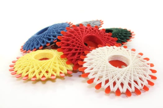 Different colored sewing thread against white background