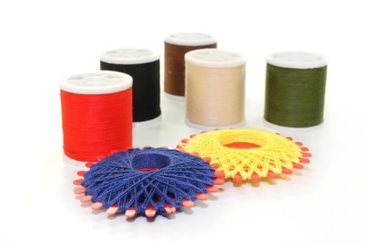 Different colored sewing thread against white background