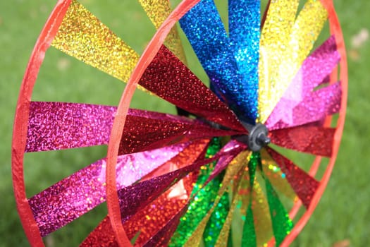 a multi-colored toy spinning wheel in a garden